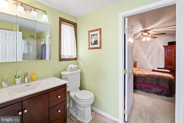 bathroom with vanity, connected bathroom, toilet, and baseboards