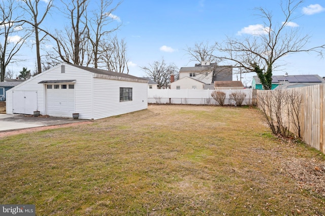 view of yard featuring an outbuilding, a detached garage, and fence