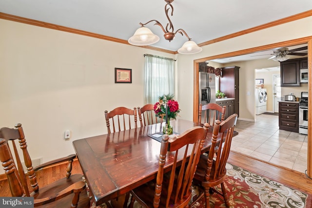 dining space featuring light wood finished floors, ornamental molding, washing machine and clothes dryer, and baseboards