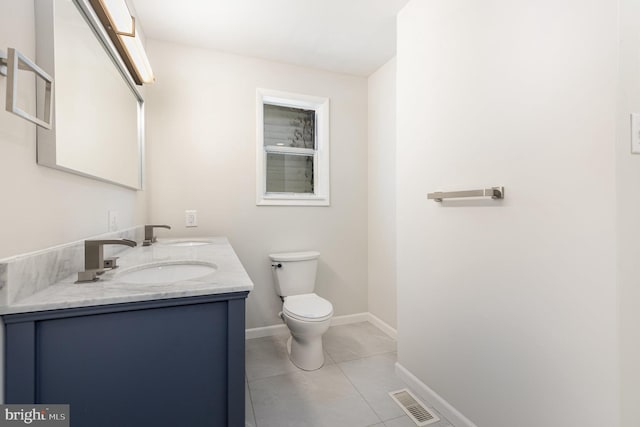 bathroom featuring toilet, a sink, visible vents, and baseboards