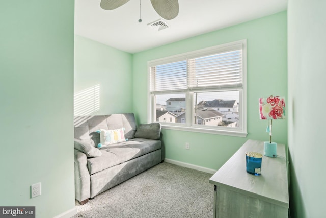 living area with light carpet, ceiling fan, visible vents, and baseboards