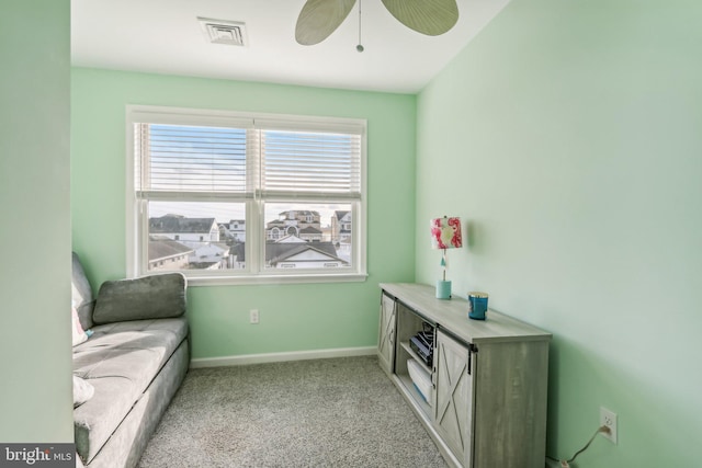 sitting room featuring light carpet, baseboards, visible vents, and a ceiling fan