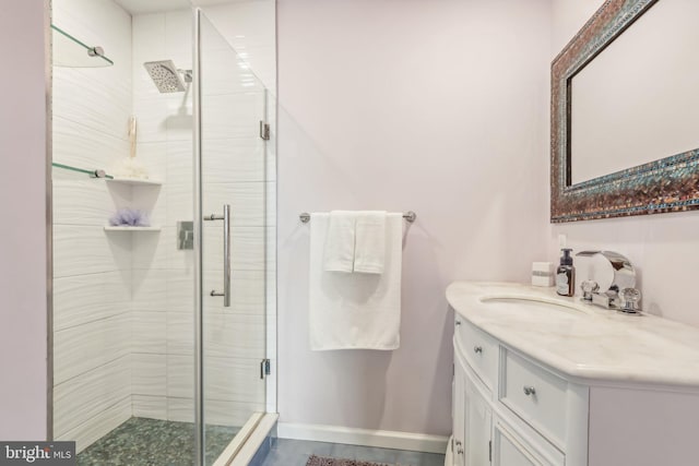 bathroom featuring a stall shower, vanity, and baseboards