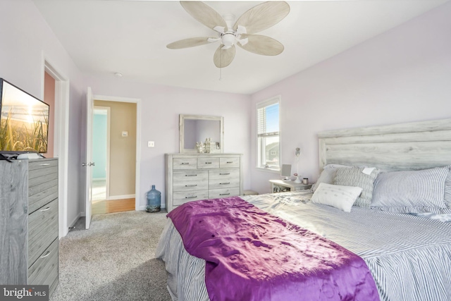 bedroom featuring a ceiling fan, light carpet, and baseboards