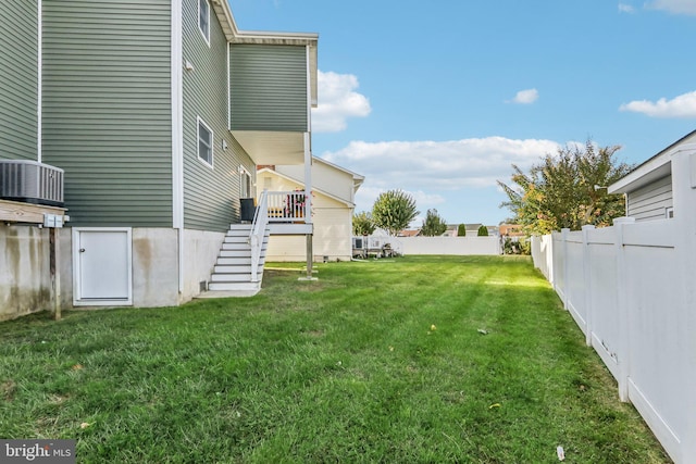 view of yard with a fenced backyard and stairs