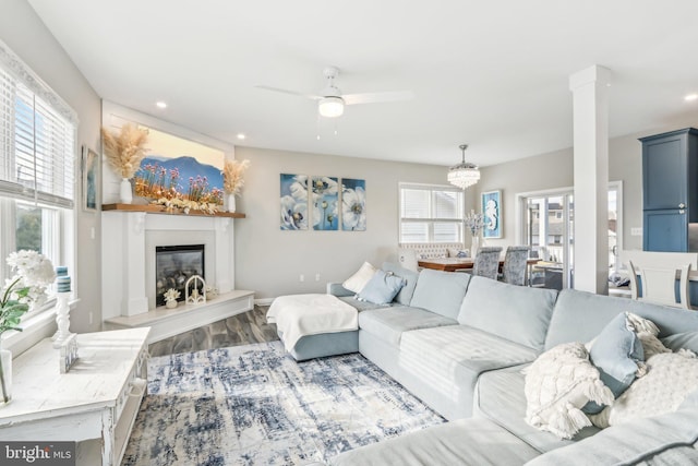 living room featuring dark wood-type flooring, plenty of natural light, a glass covered fireplace, and recessed lighting