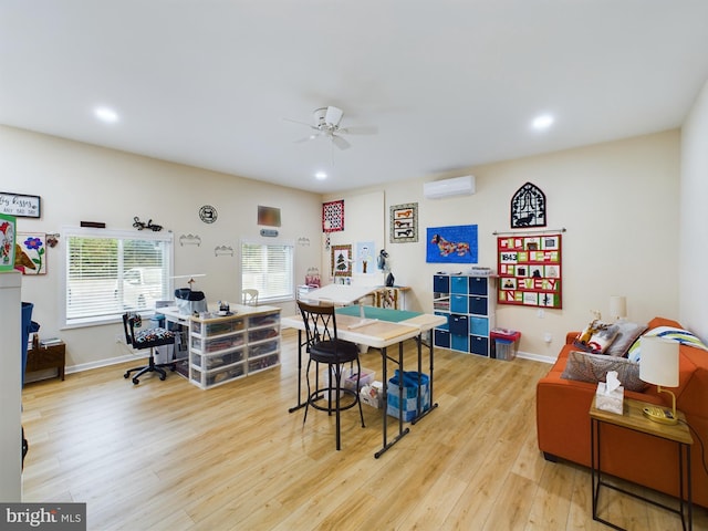 interior space featuring an AC wall unit, wood finished floors, a ceiling fan, and baseboards