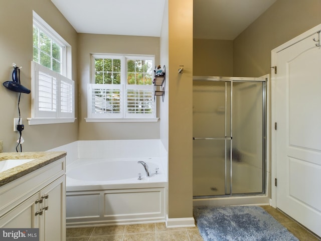 bathroom featuring a stall shower, tile patterned flooring, vanity, and a bath