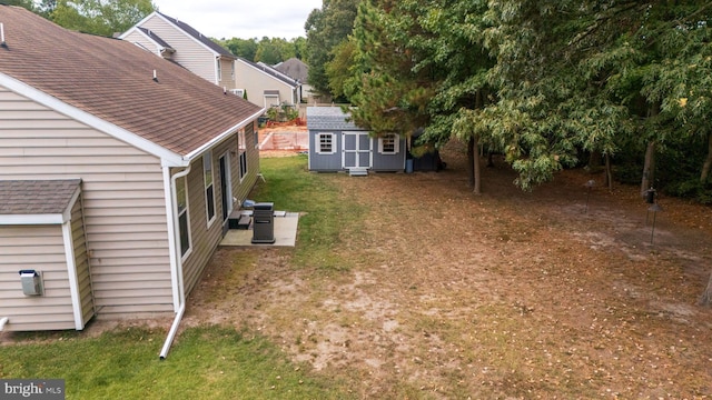 view of yard with an outdoor structure, central AC unit, and a storage unit