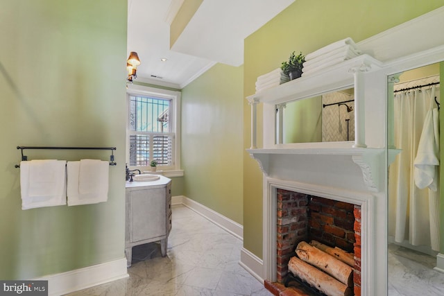 full bath with a fireplace, a sink, baseboards, marble finish floor, and crown molding