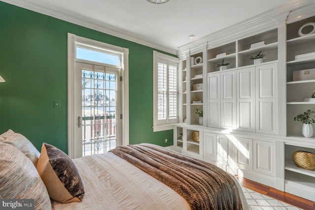 bedroom with access to exterior, ornamental molding, and wood finished floors