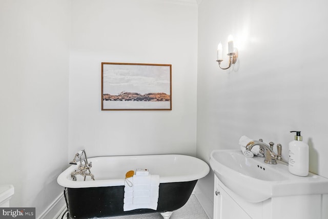 bathroom with toilet, a freestanding tub, and vanity