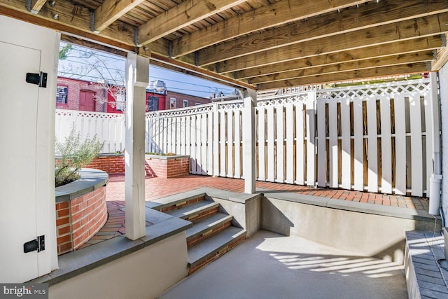 view of patio featuring a deck and fence