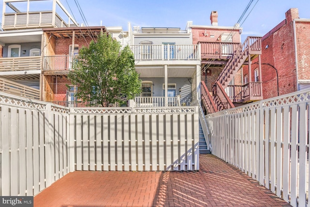 view of patio with a fenced front yard and stairs