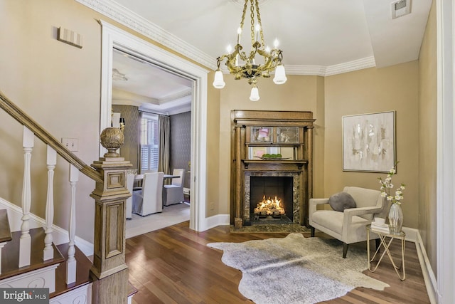 living area featuring dark wood-style flooring, crown molding, visible vents, stairway, and a lit fireplace