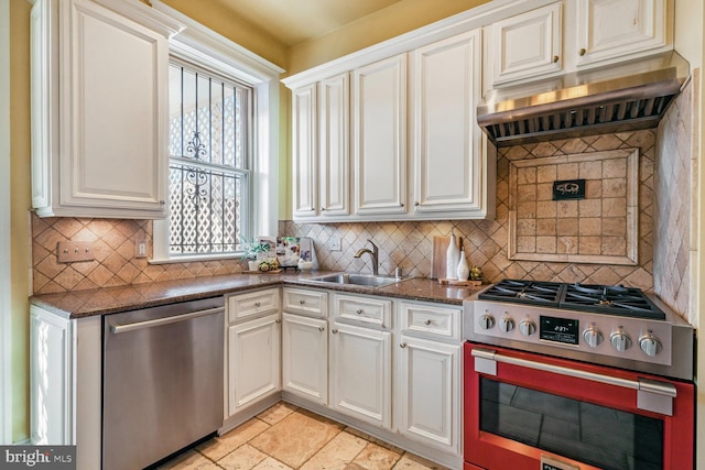 kitchen with stone tile floors, decorative backsplash, ventilation hood, stainless steel appliances, and a sink