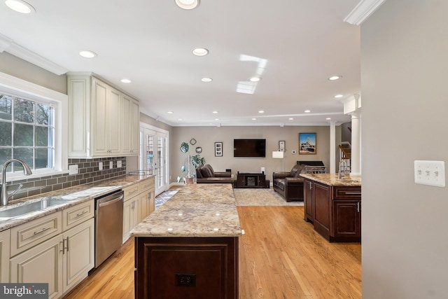 kitchen with a sink, a kitchen island, stainless steel dishwasher, and crown molding