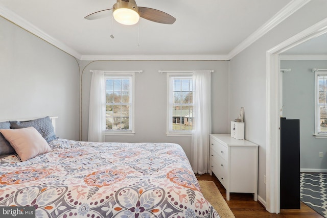 bedroom featuring dark wood finished floors, baseboards, crown molding, and ceiling fan