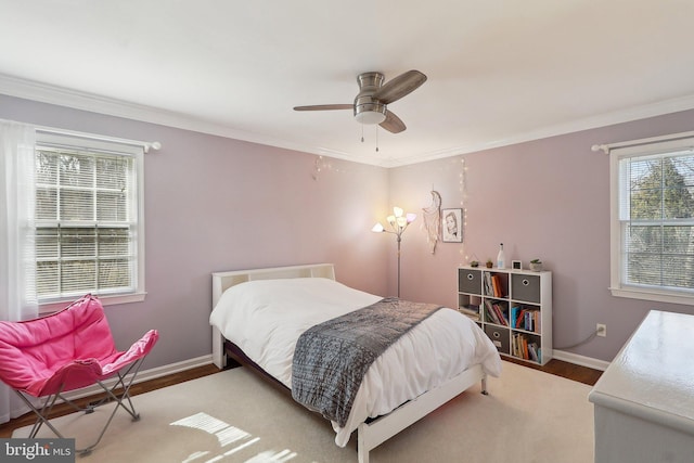 bedroom with baseboards, a ceiling fan, wood finished floors, and crown molding