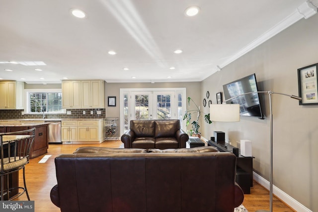 living room featuring recessed lighting, baseboards, light wood-style floors, and ornamental molding