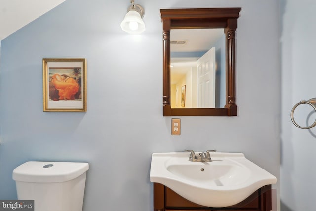 half bathroom with visible vents, toilet, and vanity