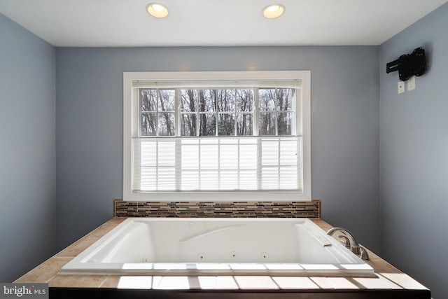 full bathroom with recessed lighting and a tub with jets