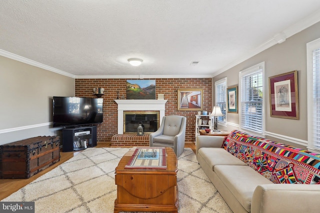 living room featuring a fireplace, a textured ceiling, crown molding, and wood finished floors