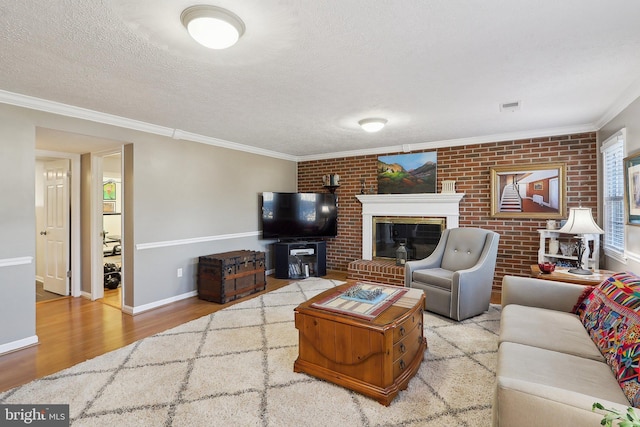 living room with crown molding, wood finished floors, visible vents, and a textured ceiling