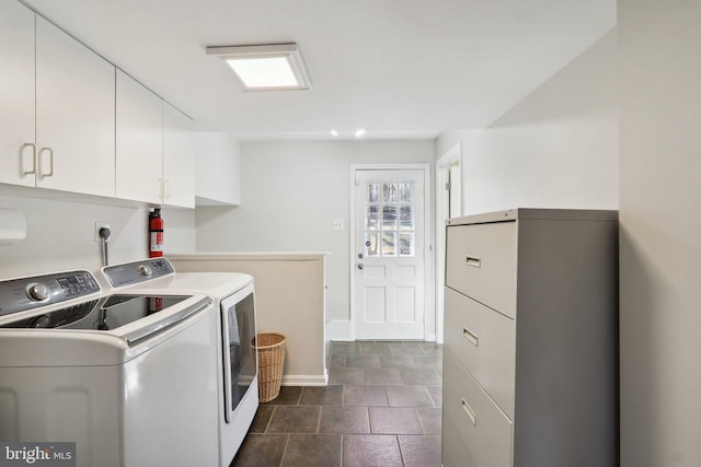 clothes washing area with cabinet space, independent washer and dryer, and baseboards