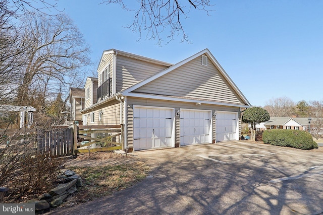 view of side of property featuring fence and driveway