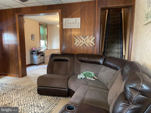 living area with carpet floors, a drop ceiling, and wallpapered walls