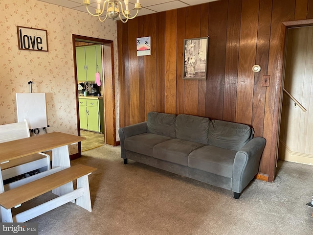 living area featuring carpet floors, wallpapered walls, and a chandelier