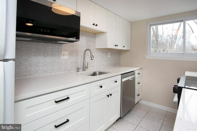 kitchen featuring light tile patterned floors, tasteful backsplash, appliances with stainless steel finishes, light countertops, and a sink