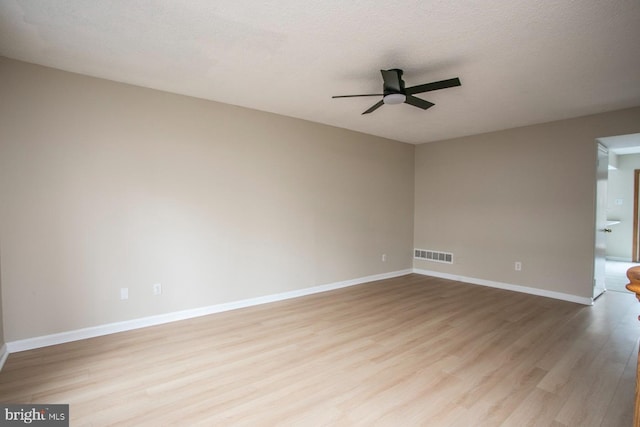 unfurnished room with visible vents, ceiling fan, a textured ceiling, light wood-type flooring, and baseboards