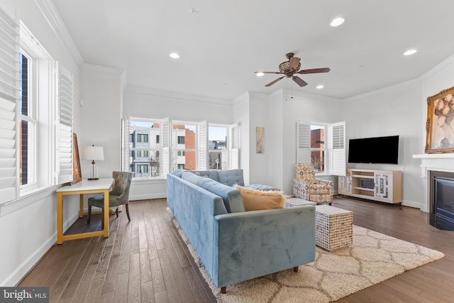 living area with a fireplace with flush hearth, recessed lighting, baseboards, and wood finished floors