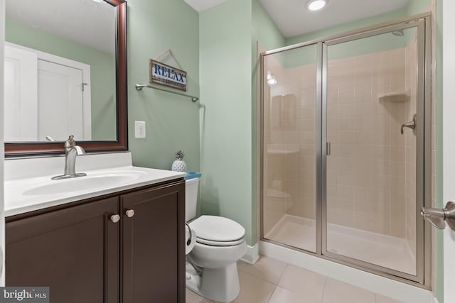 full bathroom featuring vanity, a stall shower, tile patterned flooring, and toilet