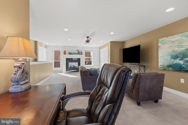 living area featuring baseboards, carpet floors, a premium fireplace, and recessed lighting