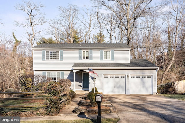 view of front of house with concrete driveway and fence