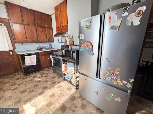 kitchen with under cabinet range hood, light countertops, appliances with stainless steel finishes, stone finish floor, and brown cabinetry