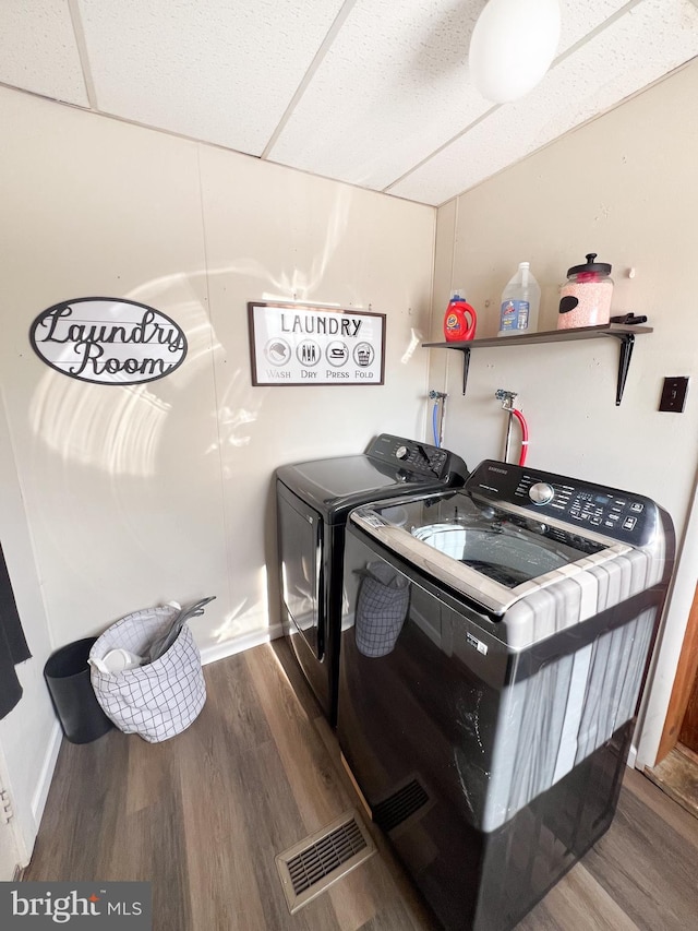 laundry room with laundry area, visible vents, wood finished floors, and independent washer and dryer