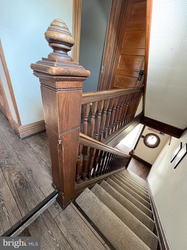 staircase with wood finished floors and baseboards