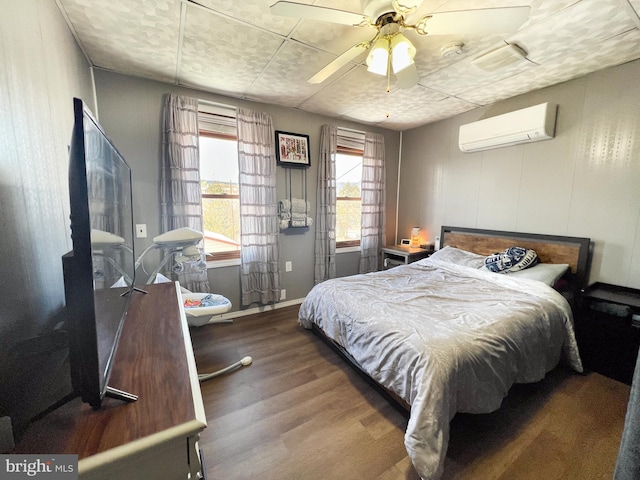 bedroom featuring a ceiling fan, wood finished floors, and a wall mounted AC