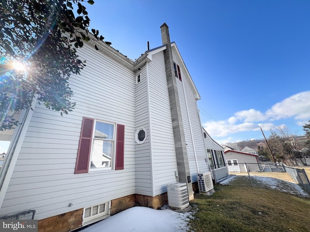 rear view of property with fence, a chimney, and a lawn