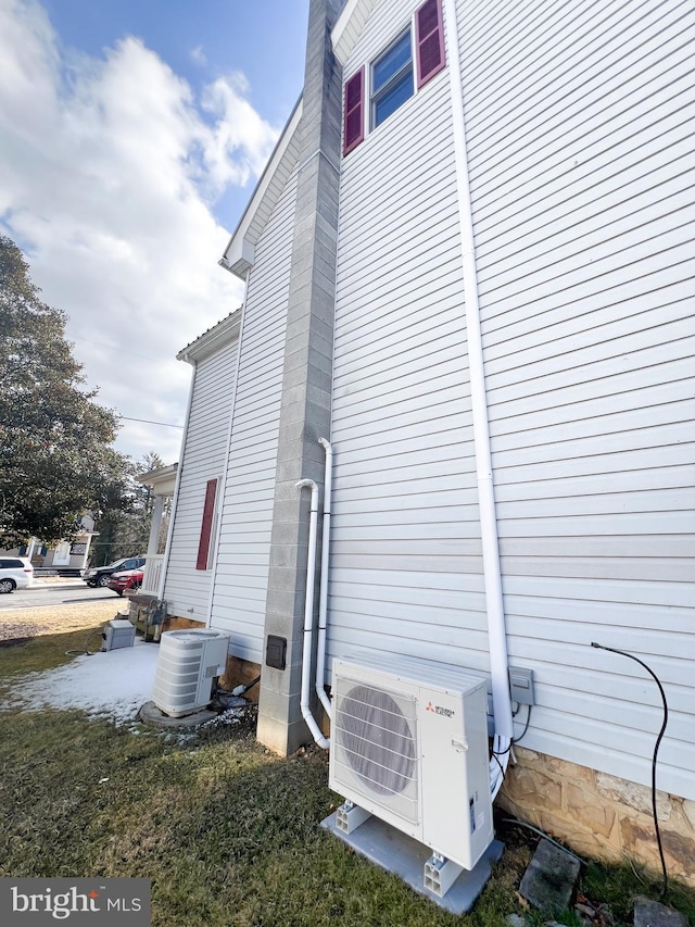 view of side of property featuring central air condition unit, ac unit, and a chimney