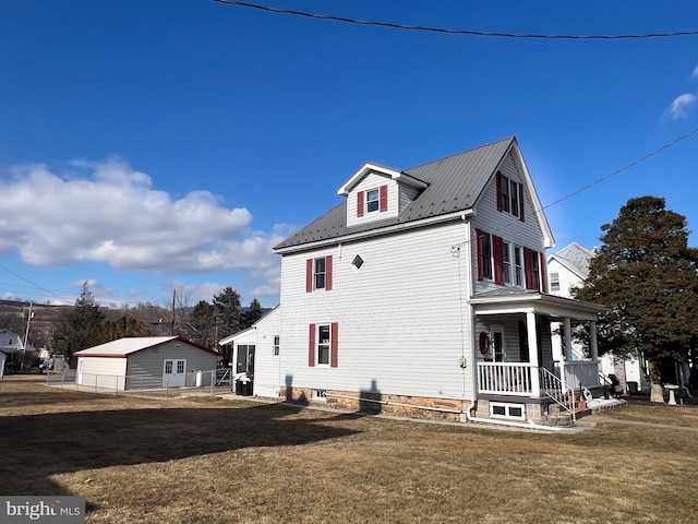 view of side of home featuring covered porch, metal roof, and a yard