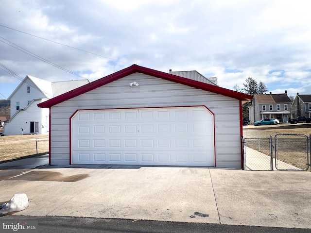 detached garage featuring a residential view and fence