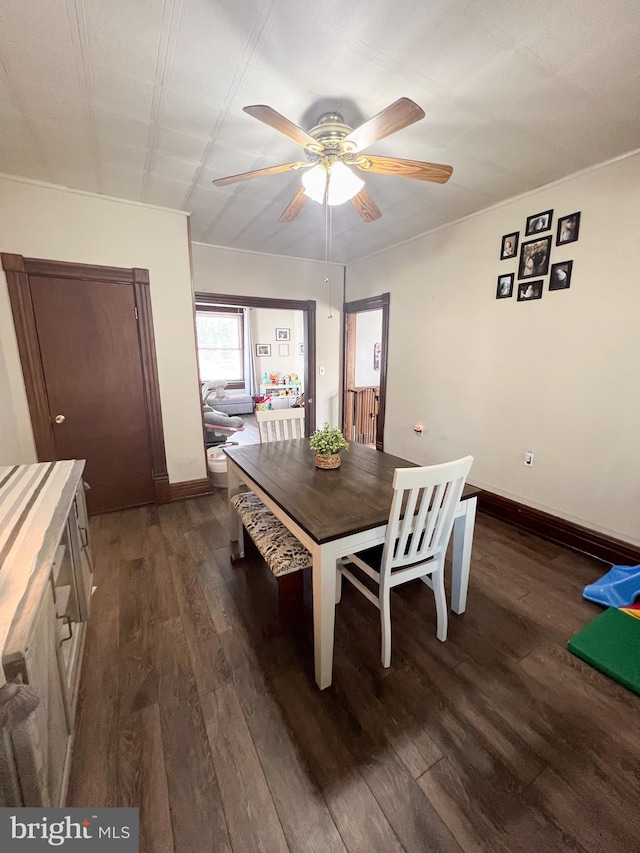 dining room featuring dark wood-style floors, baseboards, and a ceiling fan