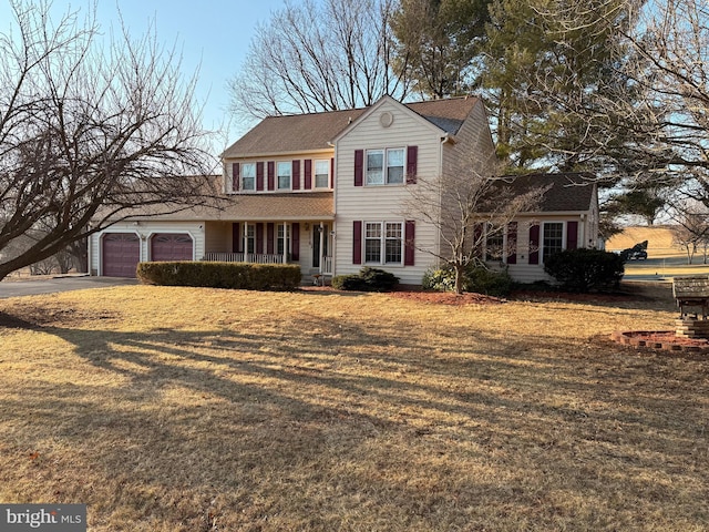 view of front of house featuring a garage, covered porch, concrete driveway, and a front yard