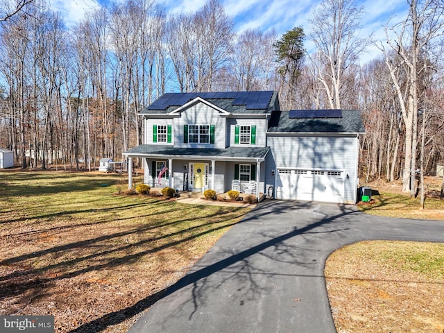 view of front facade with aphalt driveway, an attached garage, roof mounted solar panels, a porch, and a front yard