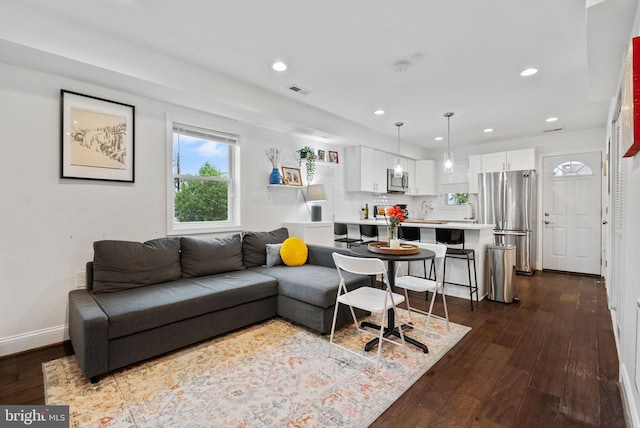 living room with recessed lighting, visible vents, dark wood finished floors, and baseboards